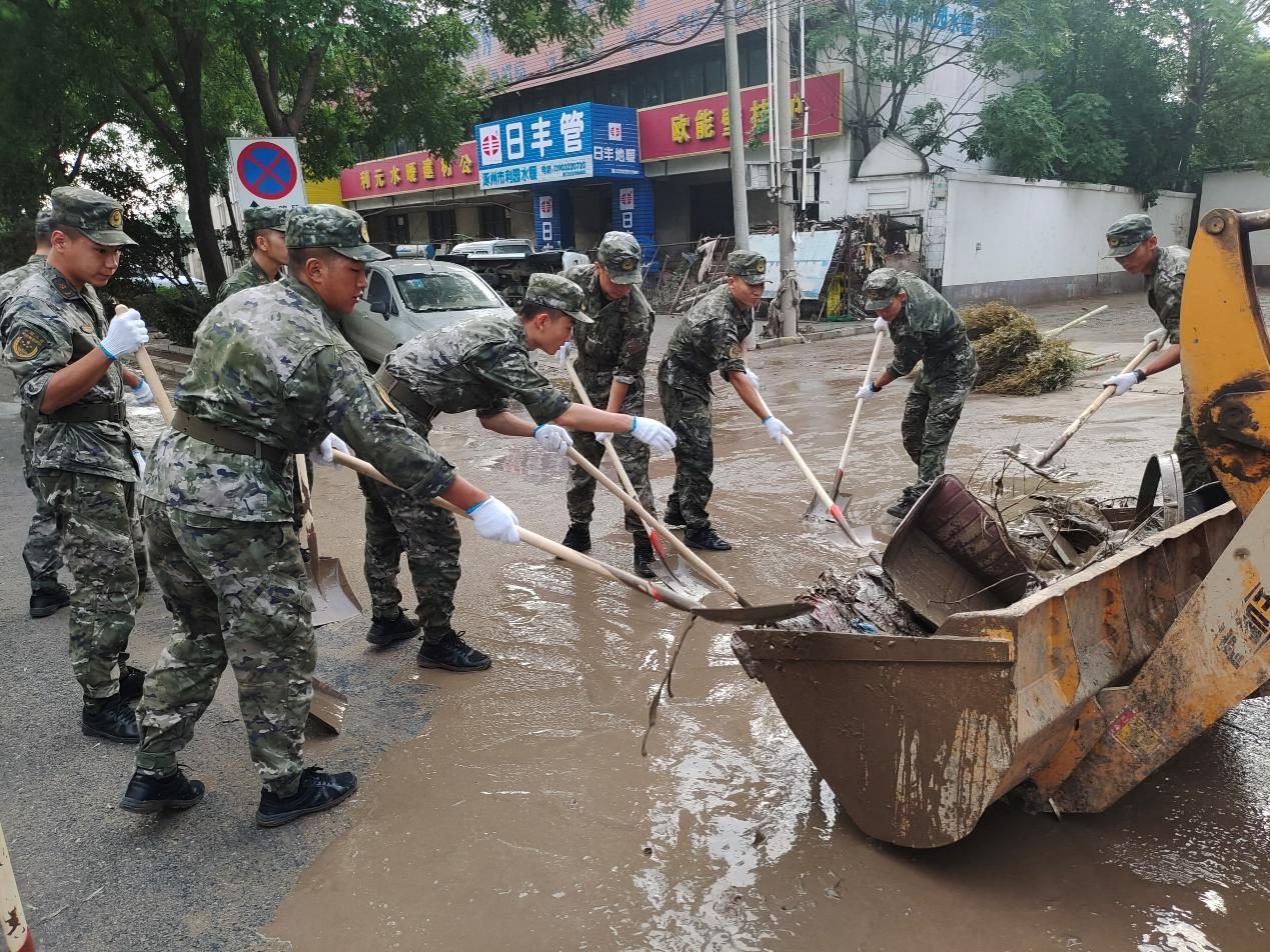 8月5日早上，武警保定支队派出70余名官兵沿涿州107国道方向对道路两旁的淤泥垃圾进行清理。郑泽楠、梁学峰摄