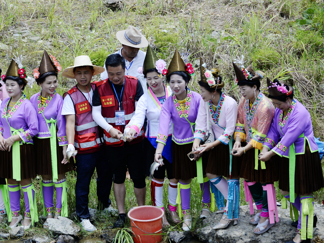 图2：当地驻村工作队员与苗家妇女开启传统放鱼节活动仪式